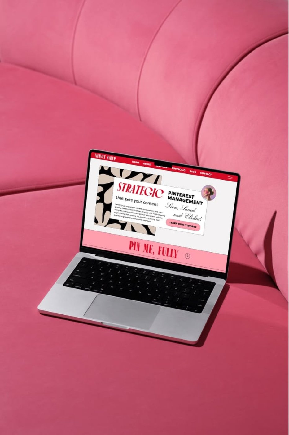Laptop showing a website design on a pink velvet sofa